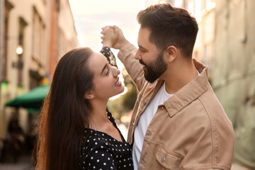 Lovely couple dancing together on city street