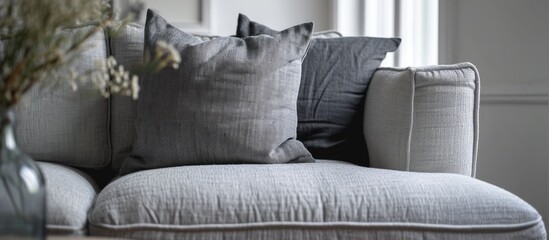 Trendy knot light grey pillow on comfortable scandinavian couch. with copy space image. Place for adding text or design