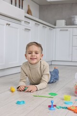 Cute little boy playing on warm floor in kitchen. Heating system