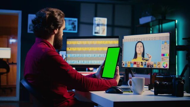 Photographer watching tutorial on mockup tablet to learn how to professionally enhance images quality. Photo editor following video guide on chroma key device about using retouching software