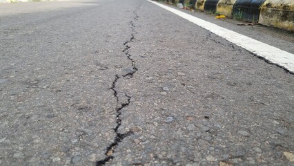 Cracked asphalt road surface background. Surface texture of old asphalt road with cracks. Alligator...