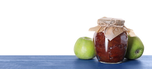 Jar with delicious apple jam and fresh fruits on blue wooden table against white background