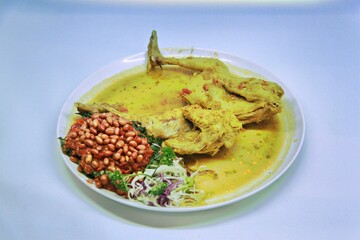 Balinese Indonesian food, Ayam Betutu. Whole chicken filled with Balinese seasoning cassava leaves, wrapped in banana leaves and steamed. Served with Sambal Matah and Roasted Peanuts.