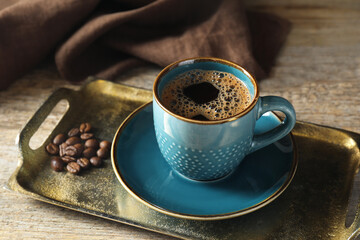 Turkish coffee. Freshly brewed beverage and beans on wooden table, closeup