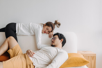 Bored and depressed mood asian lover couple lie on sofa in free empty day.