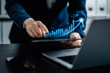 Businesswomen analyze the stock market with a digital candlestick chart and virtual bar chart,  market rise business market growth 2024, trend line increase profits, investments and financial concepts