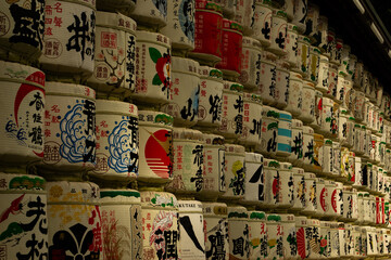 Sake barrels lined up against a wall.