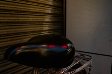 Red and blue lights reflecting off of a bicycle seat.