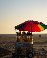 Fruit Cart with colorful umbrella by the beach at sunset in Santa Monica, Los Angeles.