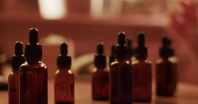 Crop craftsman mixing oils while making handmade perfume