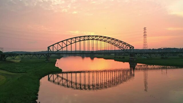 Drone Orbit shot of the train crossing a bridge over the river Rhine near Arnhem, Netherlands