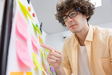 businessman working pointing post it sticky notes information on glass board at office. planning...