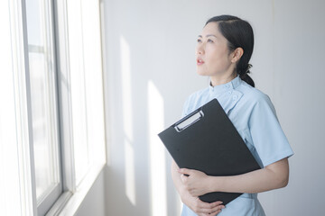バインダーとメディカル制服の女性