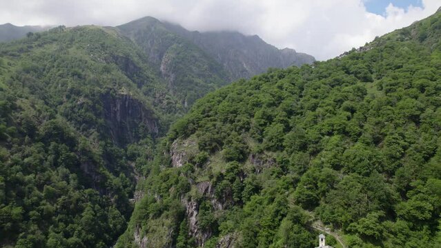 Remote church in scenic mountain forest gorge landscape Italy DRONE REVEAL 