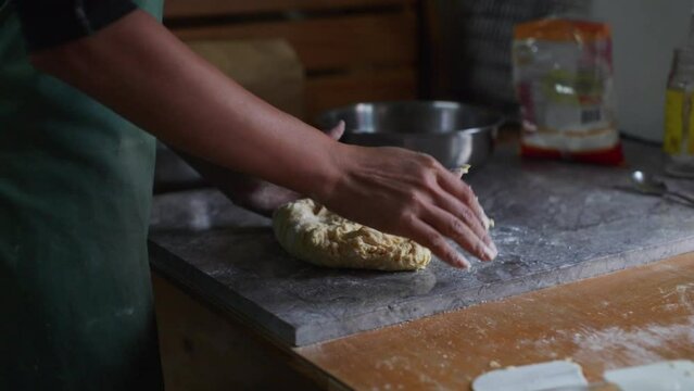 Raw dough mix kneaded by hand on marble tabletop, filmed as medium closeup slow motion shot