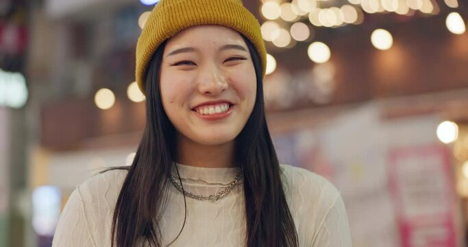Japanese woman, face and happiness in town for travel, wellness and leisure on weekend vacation. Young person, smile and portrait in tokyo city on holiday, positive attitude and relax by bokeh lights