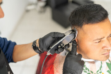 Barber cutting hair accurately with an electric razor