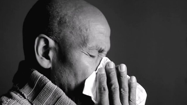 catching the flu man blowing nose with allergy sneezing after catching a cold with grey background with people stock video stock footage
