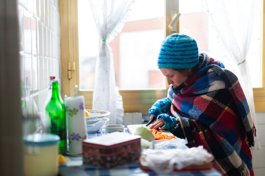 Mid Adult Female Unemployed Preparing herself a Poor Vegetable Meal in an Old Cold Apartment - Poverty Social Issues