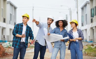 workers or architect holding plan blueprint paper and looking to something at construction site