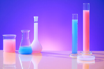 Front view of pink and blue liquid contained in glassware on a gradient pink-purple background. Empty space for product display. Simulation experiment.