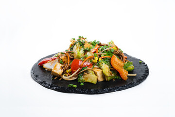 fried assorted vegetables with meat in a flat plate on a white background, side view