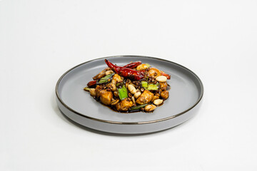 fried assorted vegetables with meat in a flat plate on a white background, side view