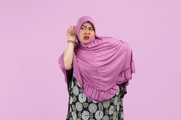 Fat Asian Muslim women are excited to listen to the conversation. Wearing pink hijab. isolated on a pink background