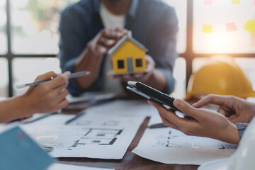 Architect or engineer are meeting to discuss house designs, modify plans for construction projects, and additions according to customer needs.