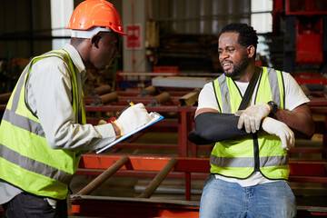 African factory worker or engineer wearing bandages splint. pain in elbow ache in arm from hard...