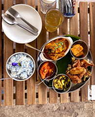 Tabletop view of bowl of Blue Butterfly Pea Flower coconut rice served with popular local dishes...