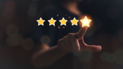 Businessmen touch glowing yellow five stars for excellent evaluation after customers use product service, ISO, and quality standard certificate concepts.