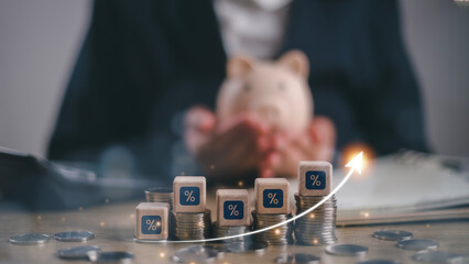 Businessman holding piggy bank and calculating income and return on investment in percentage....