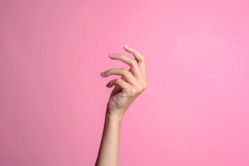 Woman hand gesture isolated on a pink studio background