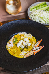 Khanom Jeen, food that has noodles as the main ingredient. Crab meat noodles on a black dinner plate, looking elegant.