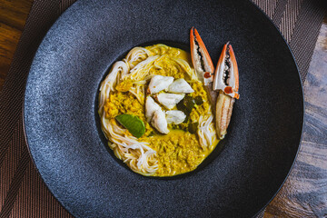 Khanom Jeen, food that has noodles as the main ingredient. Crab meat noodles on a black dinner plate, looking elegant.