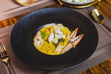 Khanom Jeen, food that has noodles as the main ingredient. Crab meat noodles on a black dinner plate, looking elegant.