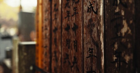 Japan, writing and wood with Japanese, spiritual and pillars with sign on a urban road outdoor....