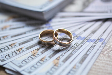 Golden wedding rings on money background