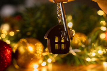 Gift key house with a keychain backdrop of Christmas tree. Building, design, project, moving to new...