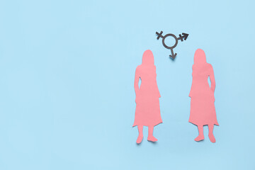 Paper female figures with transgender symbol on blue background