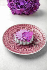 Fototapeta na wymiar Plate of panna cotta with beautiful hydrangea flowers on white table