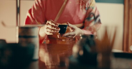Hands of woman in traditional Japanese tea house, kimono and relax with mindfulness, respect and service. Girl at calm tearoom with matcha drink in cup, zen culture and ritual at table for ceremony. - obrazy, fototapety, plakaty