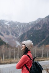 Alone in nature's embrace, Asian woman in a pink fleece. Climbing, standing by the lake, and exploring the scenic beauty of Japan's breathtaking destination.