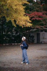 Obraz premium Asian woman in casual dress immerses herself in the cultural richness of Japanese shrines and temples, finding joy and peace in the heart of Tokyo and Kyoto.