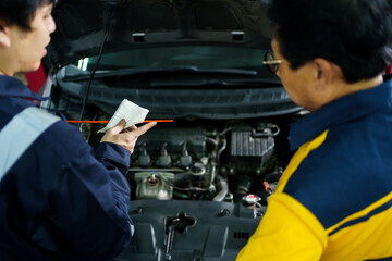 Fototapeta na wymiar Senior professional repairman inspecting an oil engine in an old car.