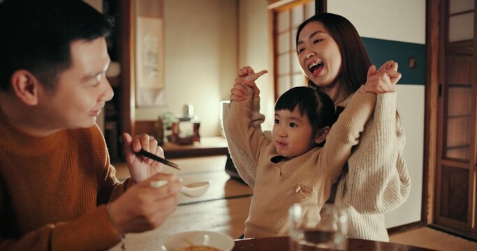 Family, excited and dinner with girl, parents and Japanese with meal, smile and home with happiness. Mother, apartment and father with kid, food and bonding together with nutrition, feeding or eating