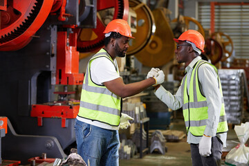 African factory workers or engineer shaking hands together in the factory