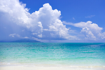 Obraz premium Beach sand for summer vacation concept. Beach nature and summer seawater with sunlight light sandy beach Sparkling sea water contrast with the blue sky.Beach sand for summer vacation concept.