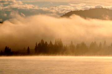 Fototapeta premium Atmospheric morning fog over Lake Yazevoe in eastern Kazakhstan. Lake Yazevoe is located at an altitude of 1685 meters above sea level. It is part of the State National Natural Park 